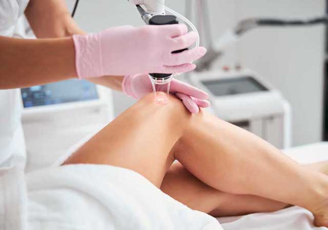 Woman getting laser hair removal treatment on legs