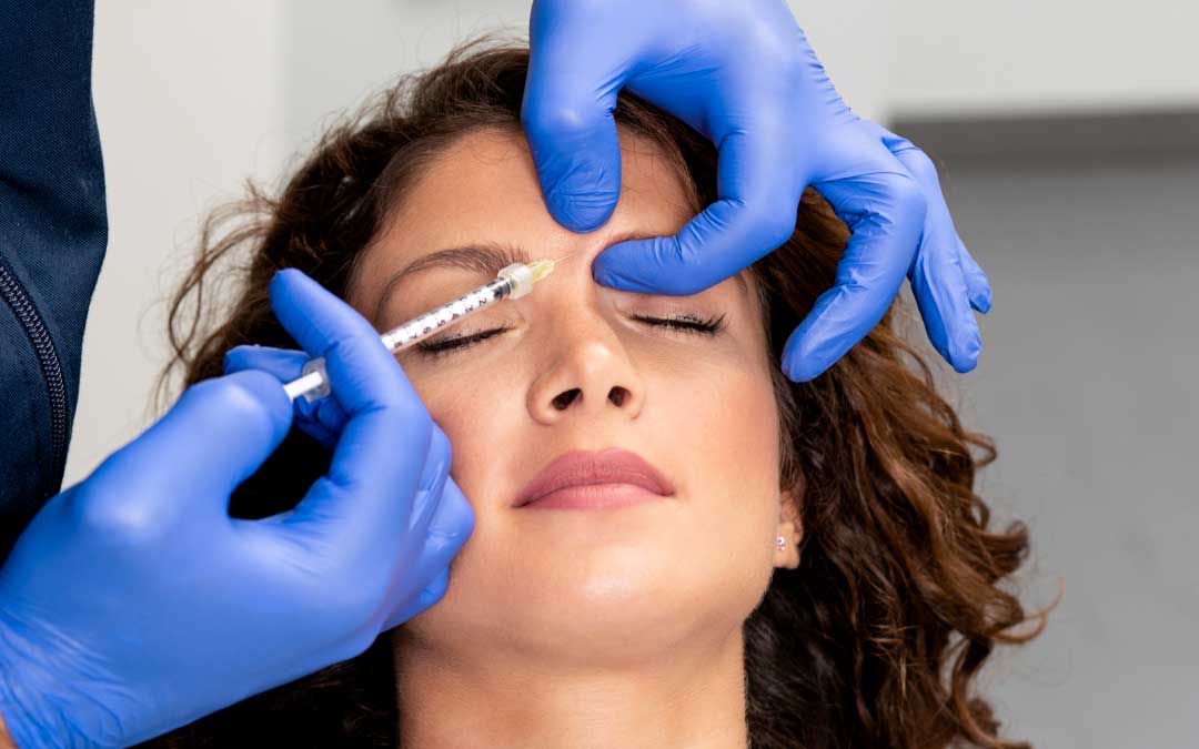 Woman receiving Botox injection between eyebrows