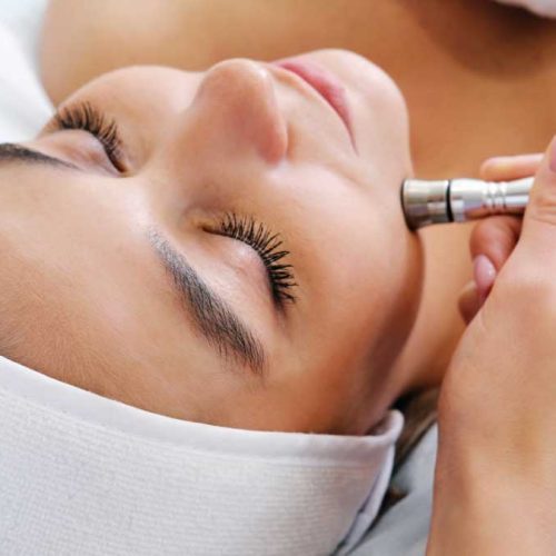 Women getting microdermabrasion treatment to her face