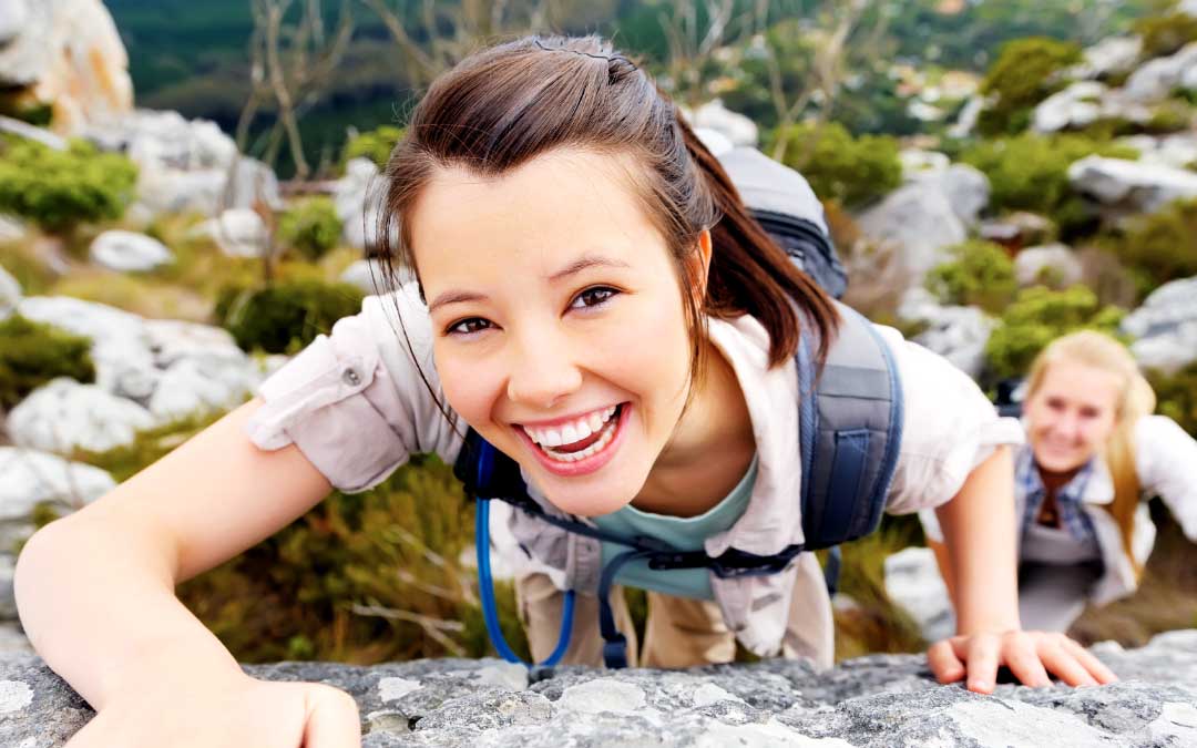 Women with healthy, glowing skin climbing outdoors